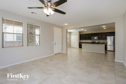 an empty kitchen and living room with a ceiling fan