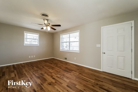 a living room with wood floors and a ceiling fan