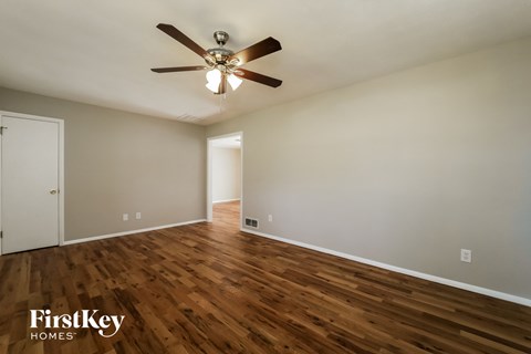 a living room with hardwood flooring and a ceiling fan