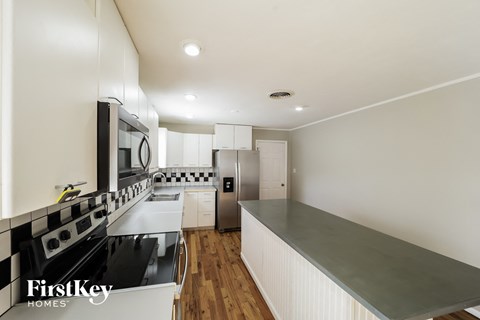 a renovated kitchen with stainless steel appliances and white cabinets