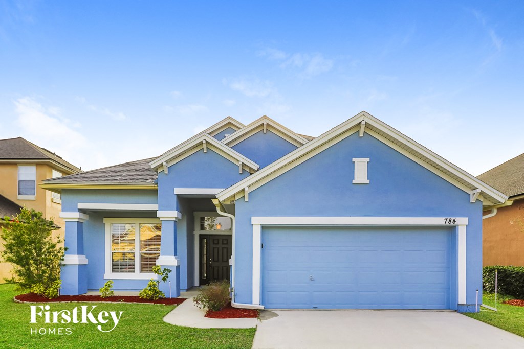 A blue house with a garage door is for sale.