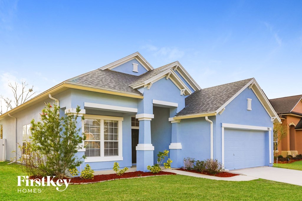 A blue house with the words "FirstKey Homes" on the lawn.