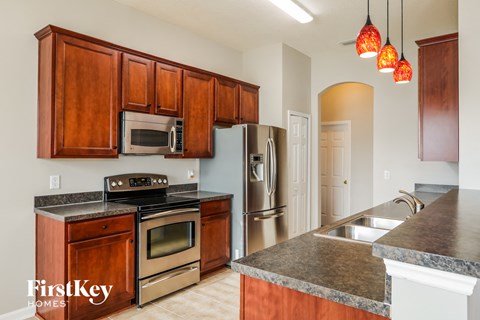 A kitchen with wooden cabinets and a granite countertop.