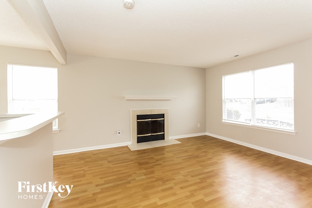 a living room with a fireplace and wooden floors