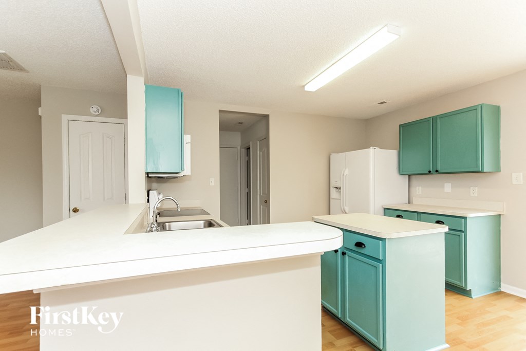 a kitchen with blue cabinets and a white counter top and a sink