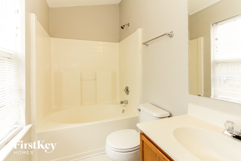 a bathroom with a tub and a sink and a toilet
