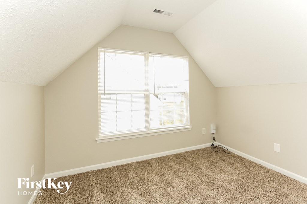 a bedroom with carpet and a large window