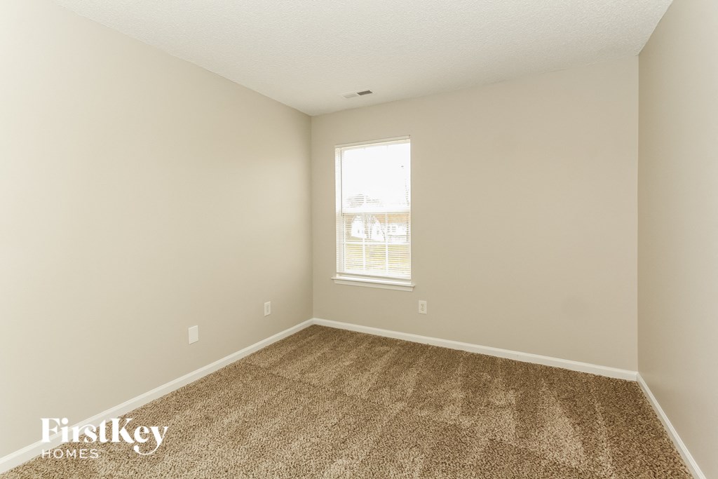 an empty room with carpet and a window