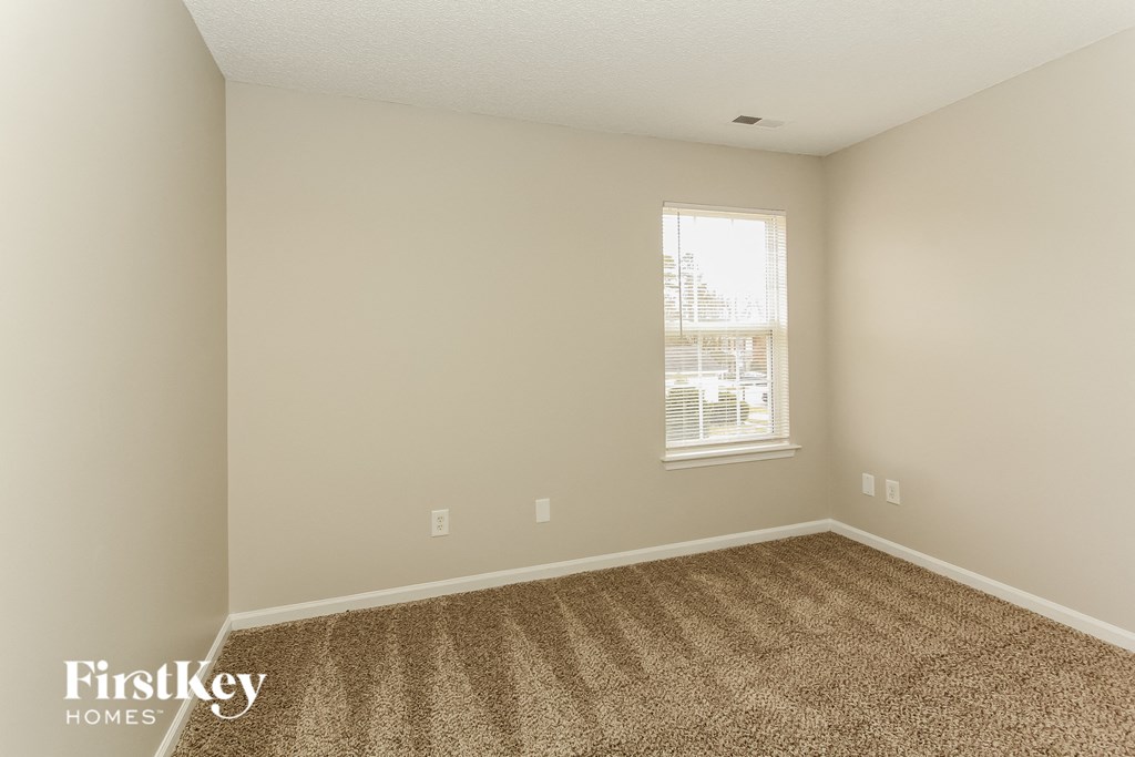 an empty room with carpet and a window