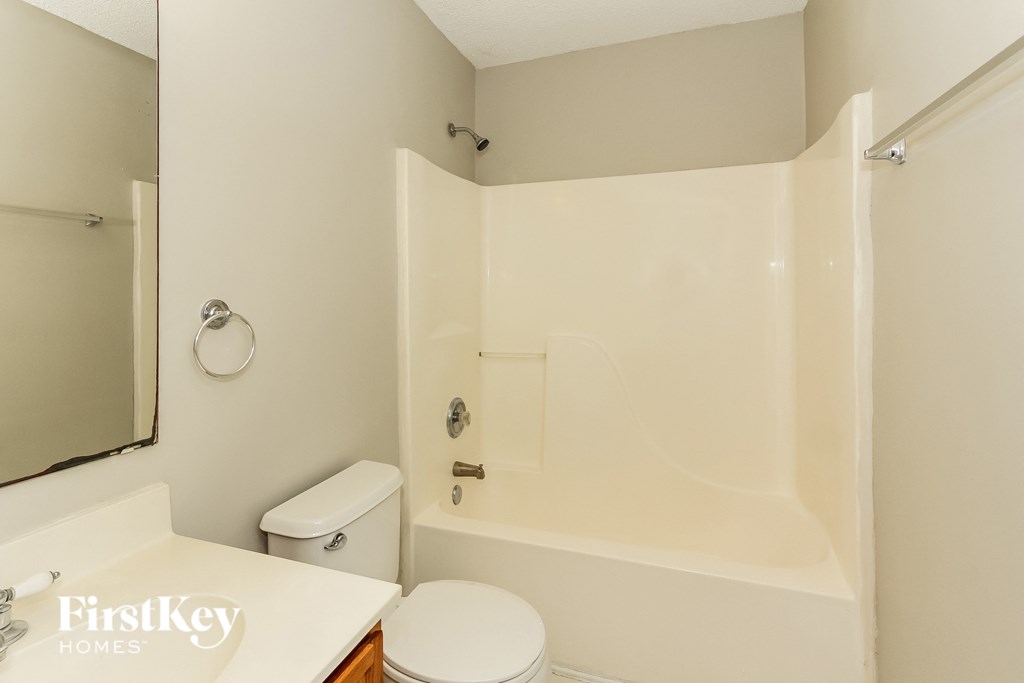 a bathroom with a shower and a toilet and a sink