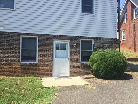 the front of a brick house with a white door