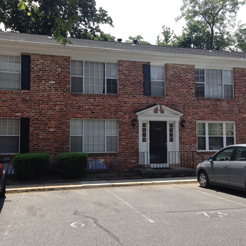 the front of a brick building with a car parked in front