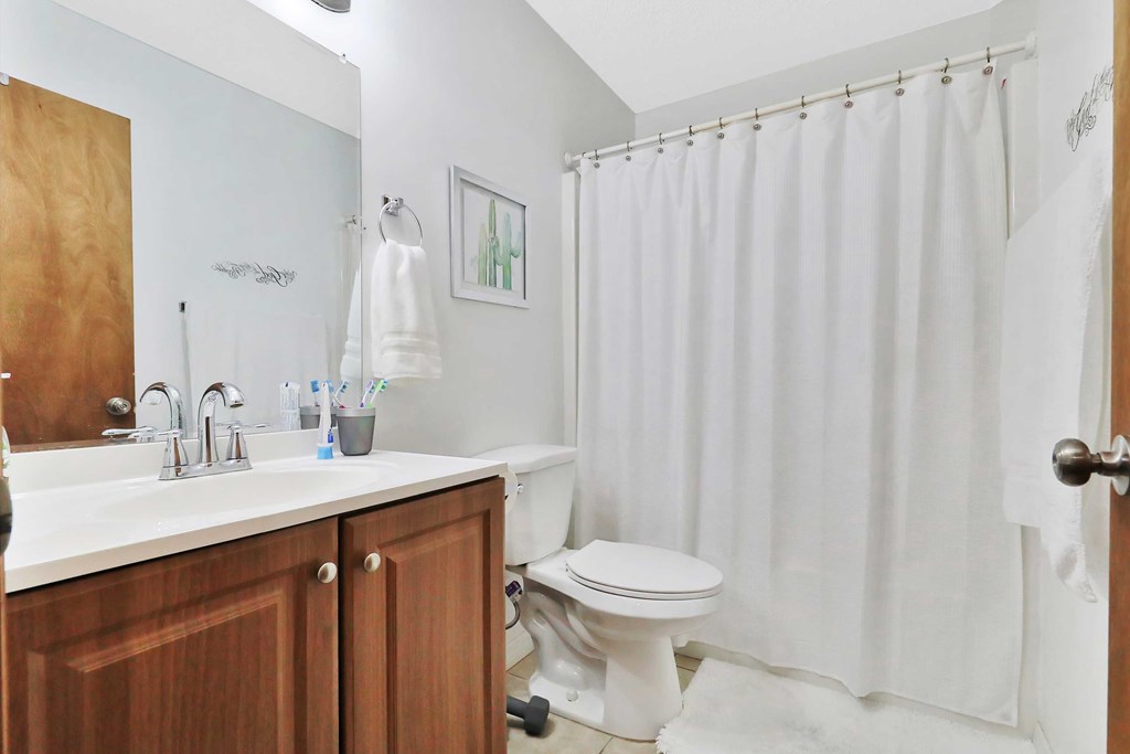 a bathroom with a white shower curtain and a toilet