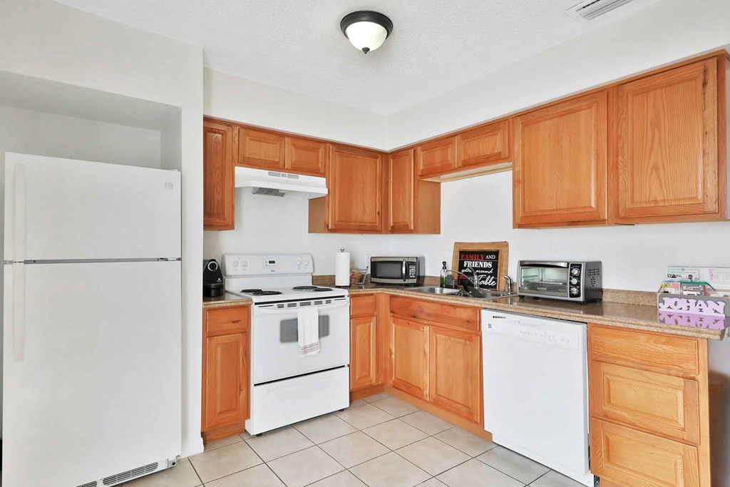 a kitchen with white appliances and wooden cabinets