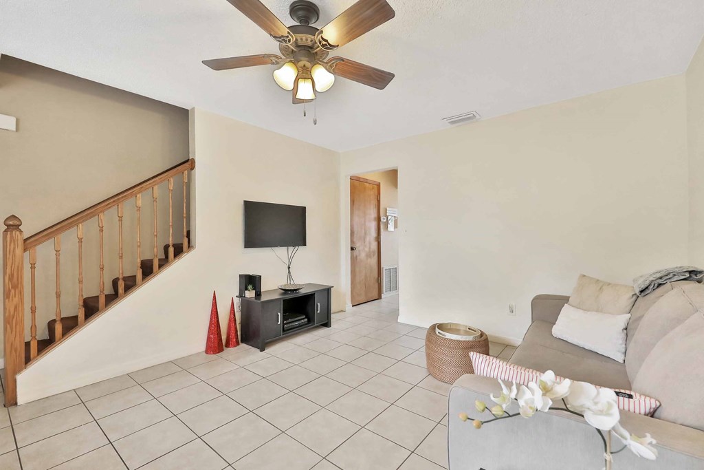 a living room with a couch and a ceiling fan