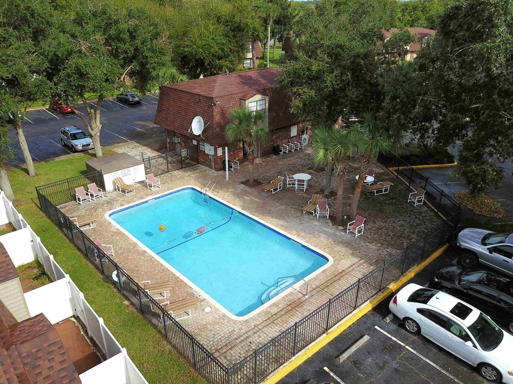 an aerial view of a swimming pool in front of a house
