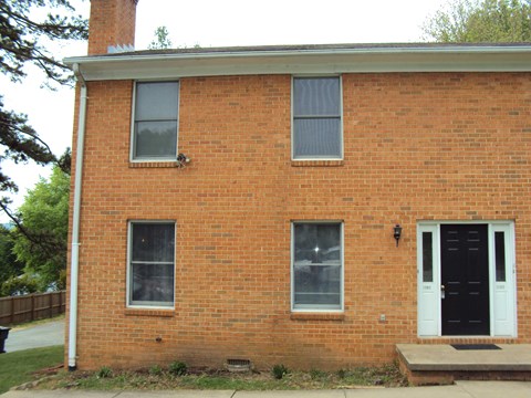 an old brick building with a black door and windows