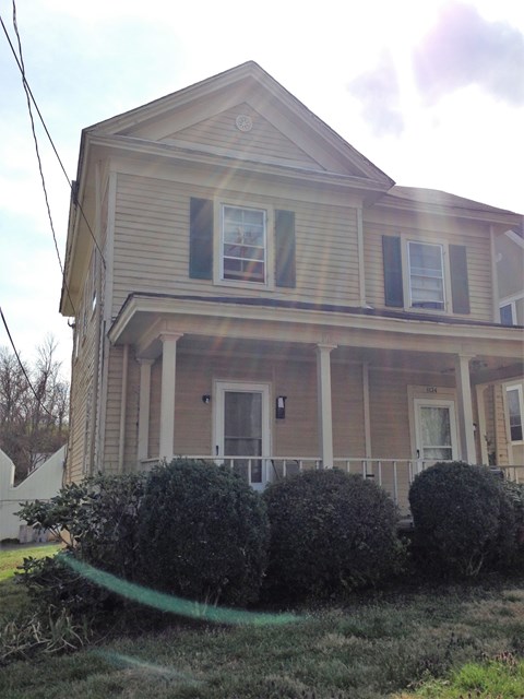 A house with a green hose in front of it.