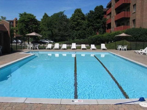 a large swimming pool with chairs and umbrellas