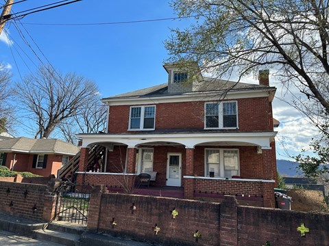 A red brick house with a white door and windows.