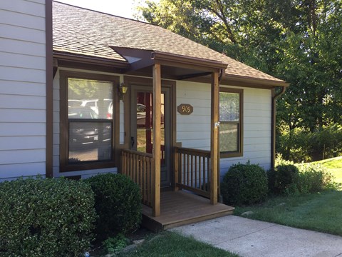 a small porch with a porch swing in front of a house