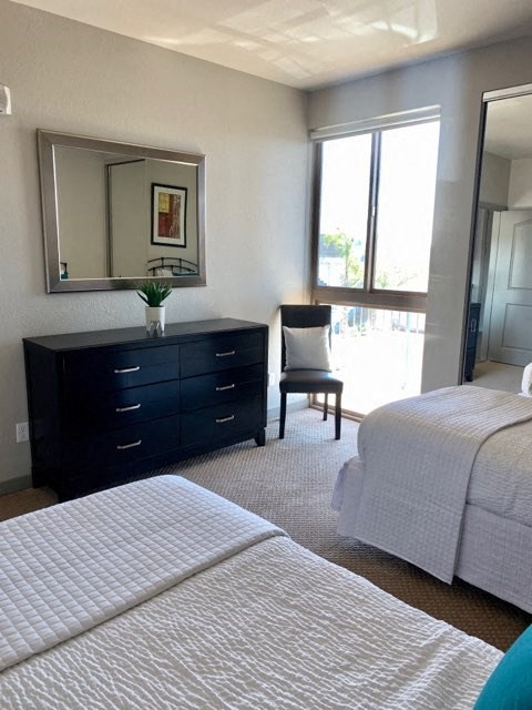 a bedroom with two beds and a dresser with a mirror
