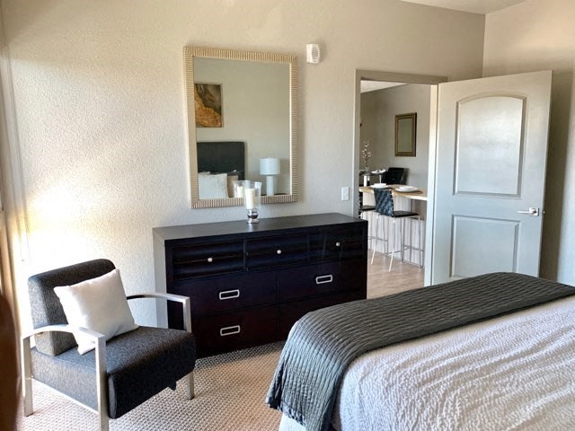 a bedroom with a bed and a dresser and a mirror