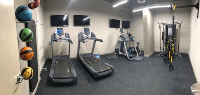 a gym with treadmills and other exercise equipment in a room