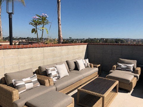 a patio with couches and a table on a roof