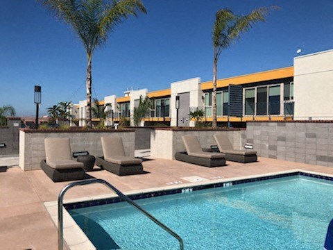 a swimming pool with lounge chairs next to a building