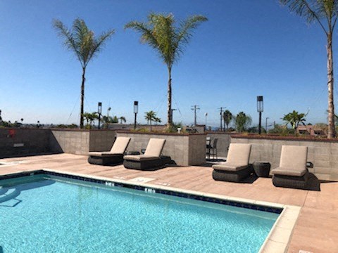 a swimming pool with four lounge chairs next to it