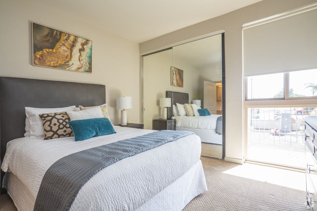 a bedroom with a large bed and a sliding glass door