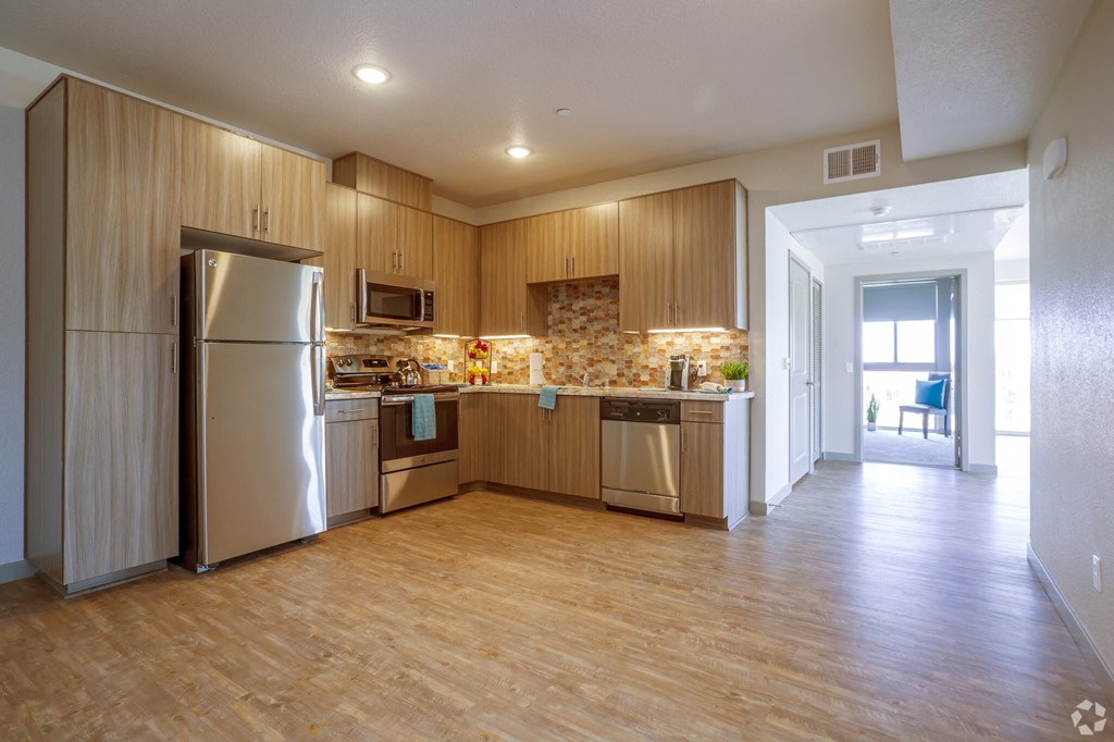 a large kitchen with stainless steel appliances and wooden cabinets