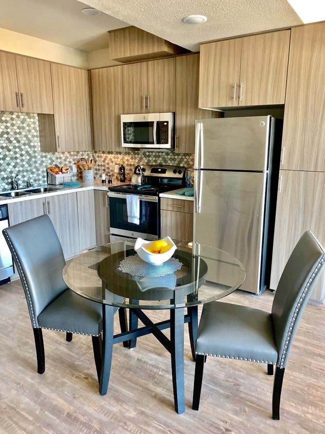 a kitchen and dining room with a glass table and chairs