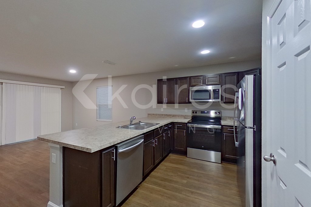 A kitchen with a white countertop and stainless steel appliances.