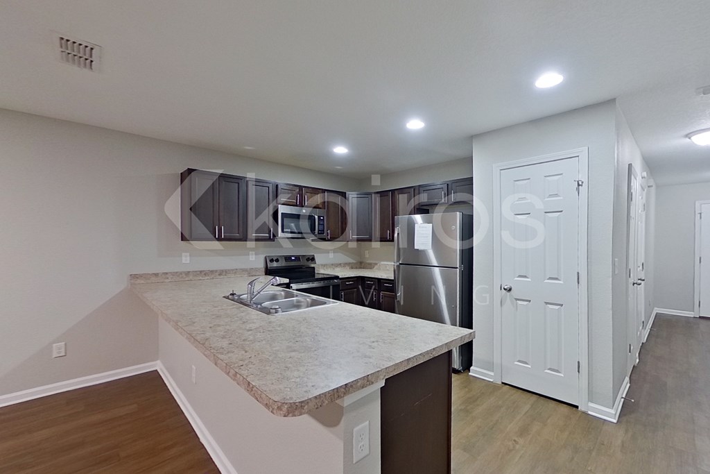 A kitchen with a granite countertop and stainless steel appliances.