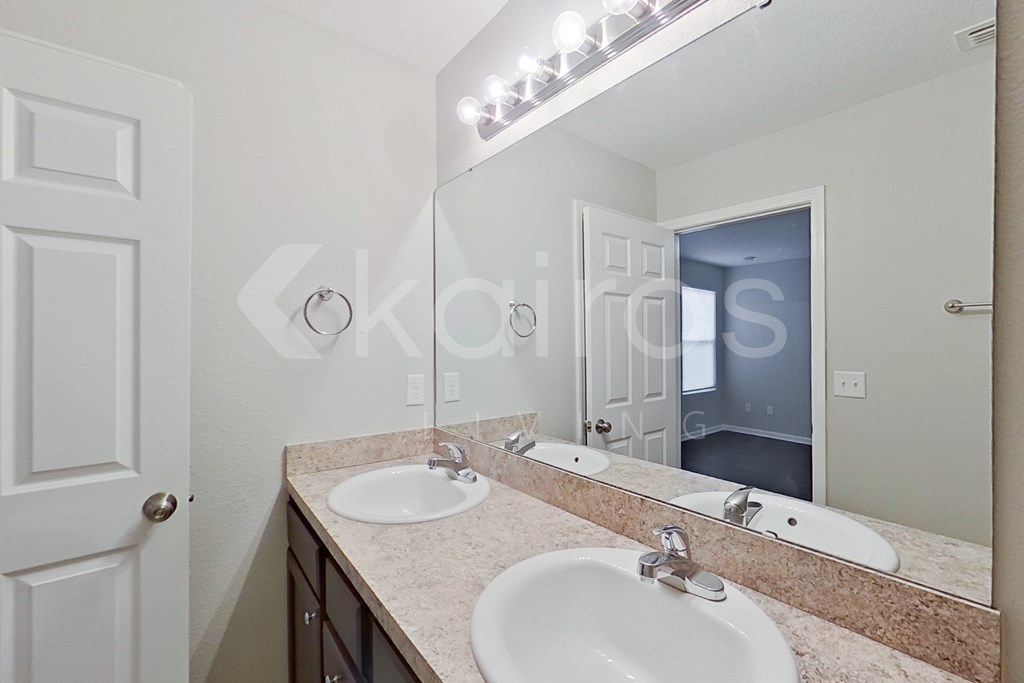 A bathroom with a sink, mirror, and lights.