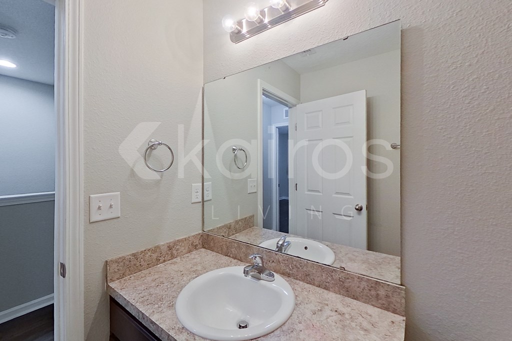 A bathroom with a sink and mirror.