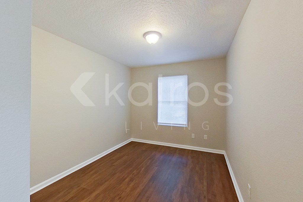 A room with wooden flooring and a window.