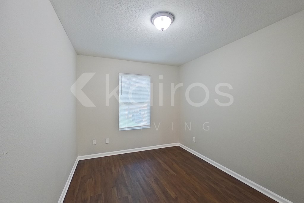 A room with a window and wooden floors.