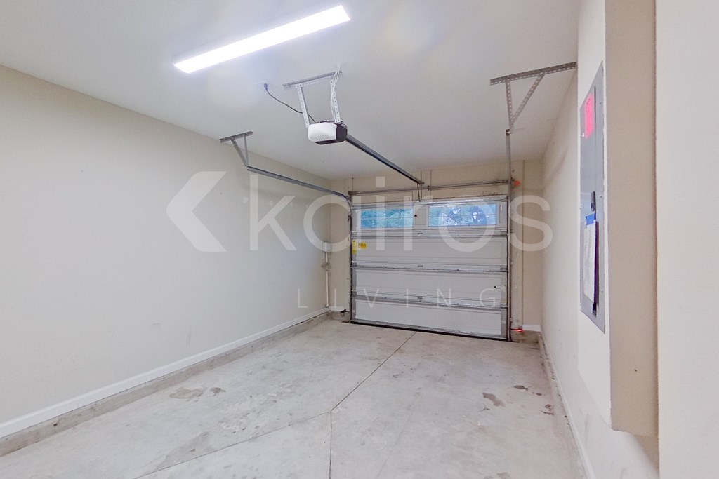 A room with a white wall and a window with blinds.