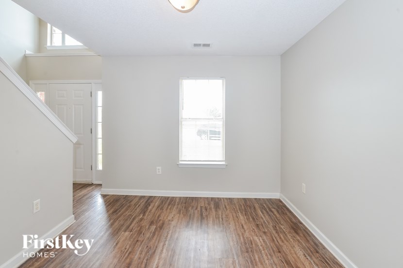 A room with wooden floors and a window letting in light.