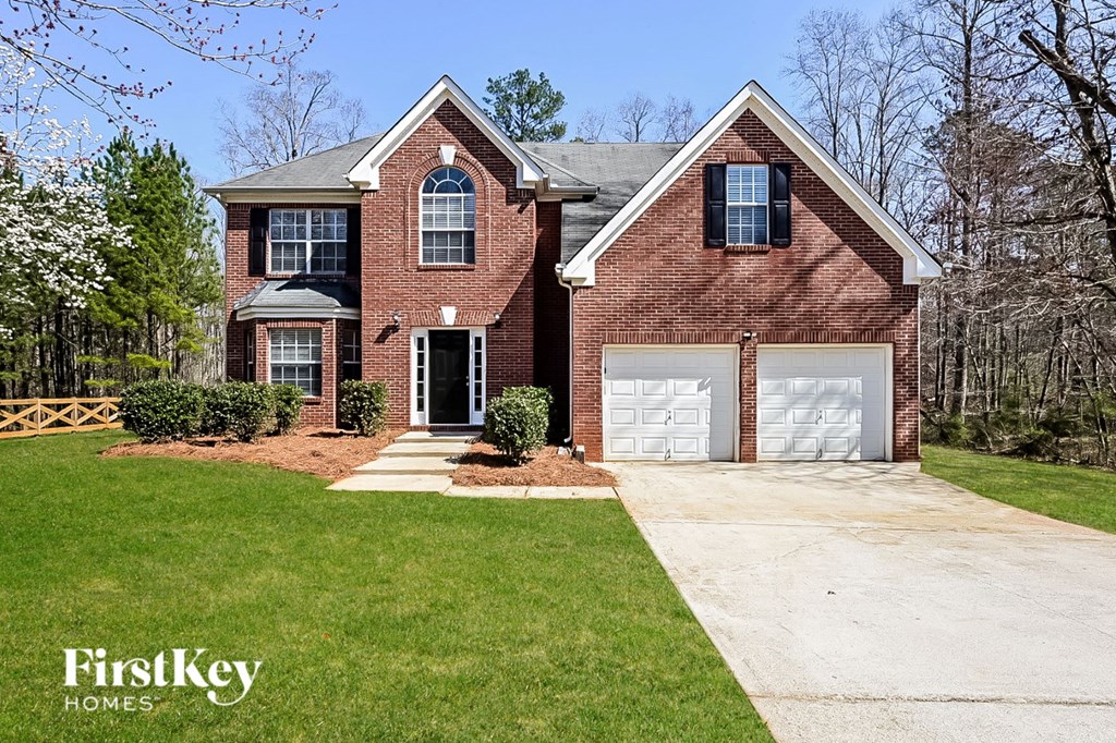 a brick house with a white garage door and a lawn