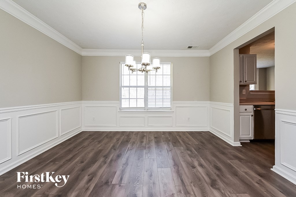 an empty dining room with wood flooring and a window