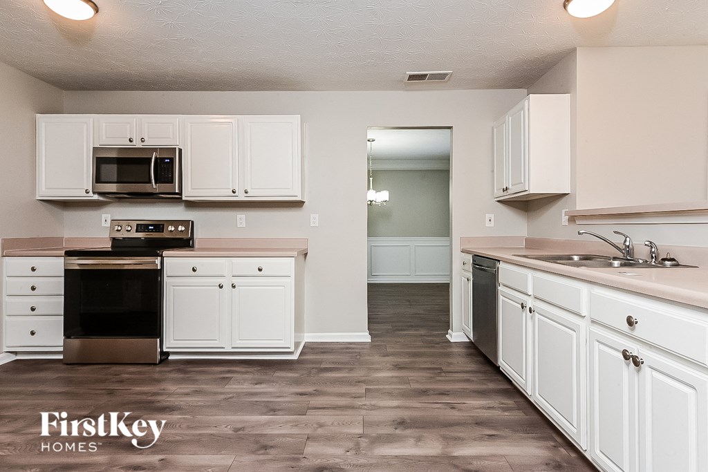 a kitchen with white cabinets and stainless steel appliances