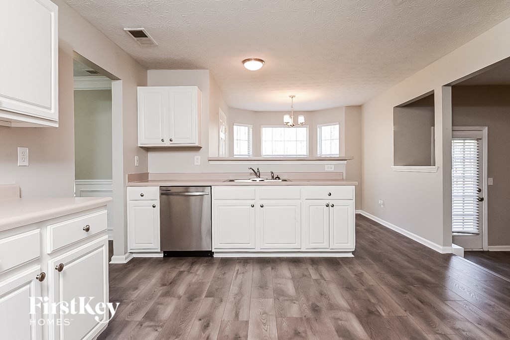 a white kitchen with white cabinets and a stainless steel dishwasher