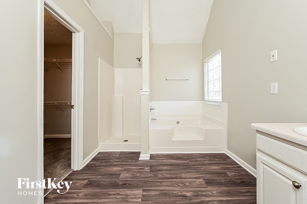 a bathroom with a tub and a sink and a mirror