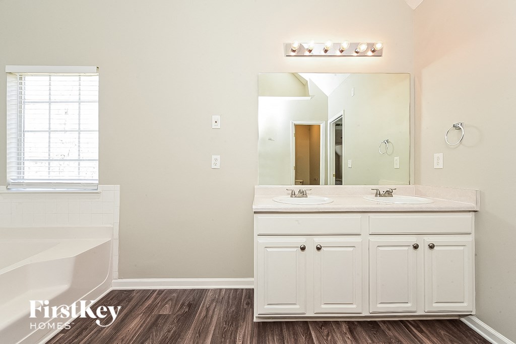a bathroom with white cabinets and a sink and a mirror