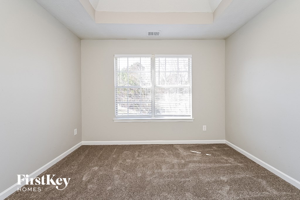 a bedroom with carpet and a window