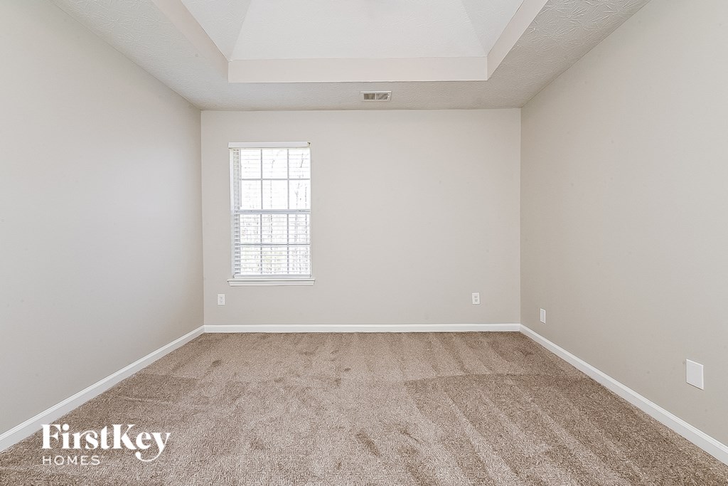 a empty room with carpet and a window